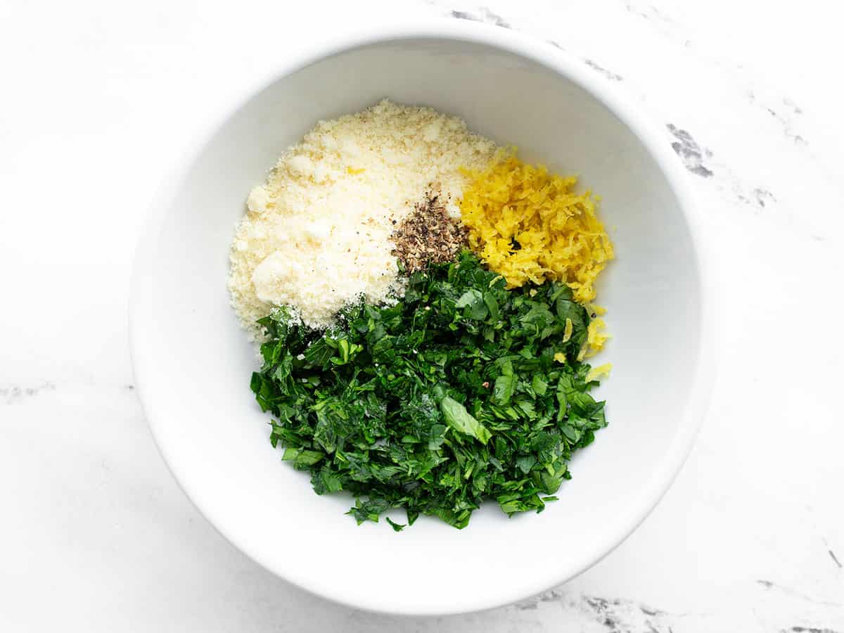 Chopped parsley, lemon zest, Parmesan, and pepper in a bowl