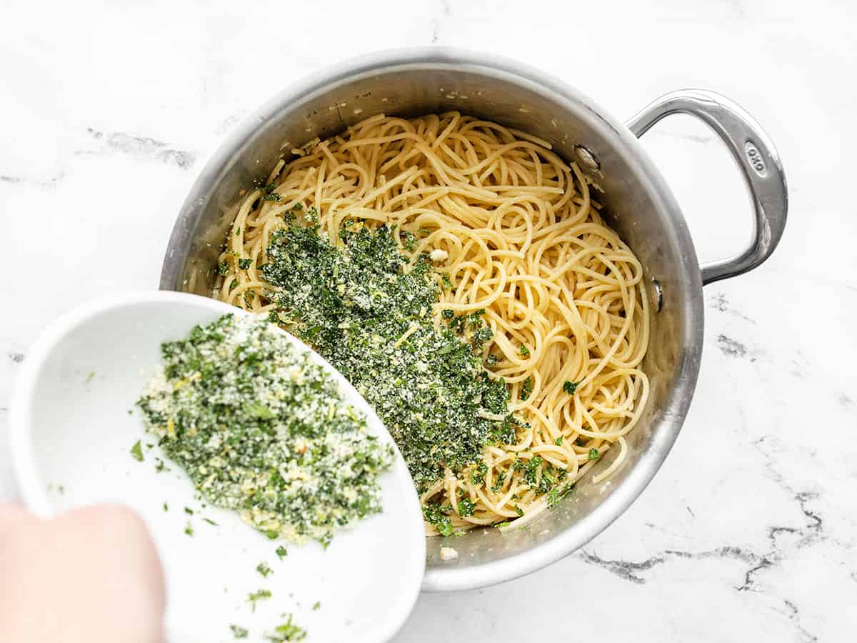 parsley and parmesan mixture being poured into the pot