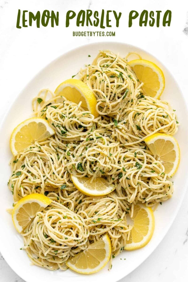 Overhead view of an oval platter full of lemon parsley pasta, title text at the top