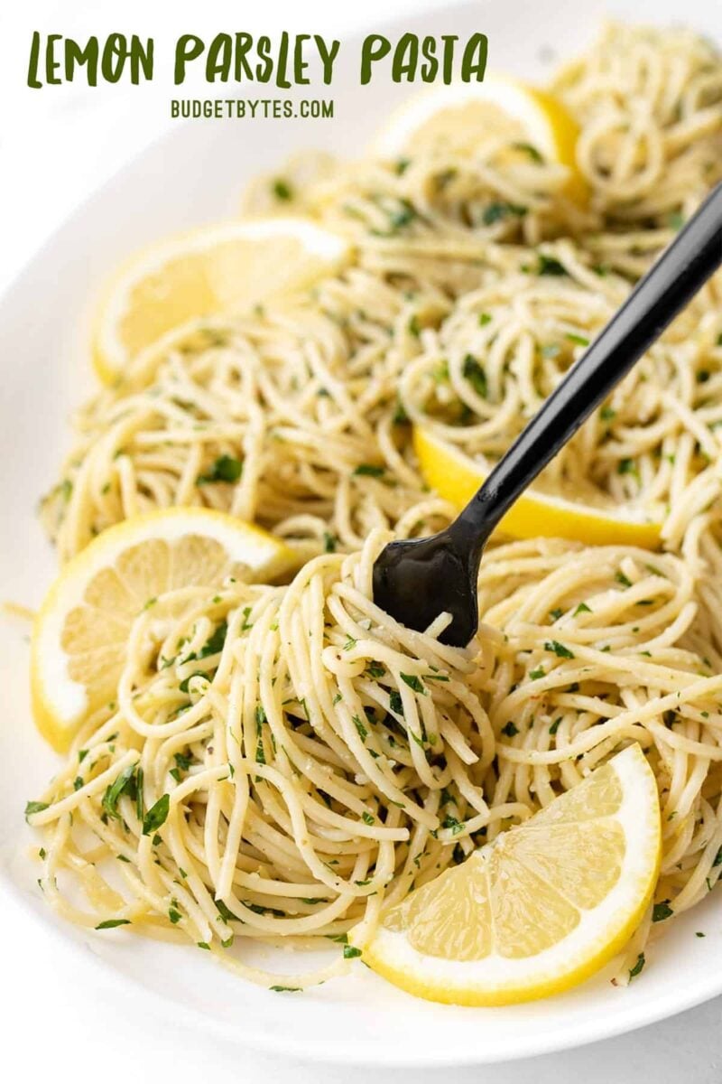 Close up view of lemon parsley pasta being twirled onto a fork, title text at the top