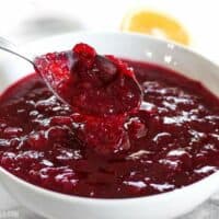 cranberry sauce dripping off a spoon into a bowl