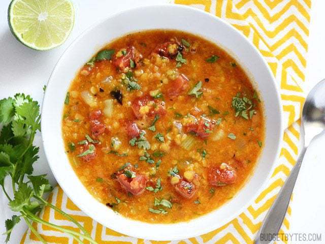 Mexican Red Lentil Stew plated in white bowl and ready to eat- BudgetBytes.com