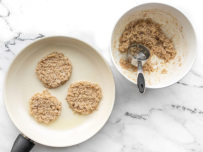 Rice pancakes being portioned into a hot skillet