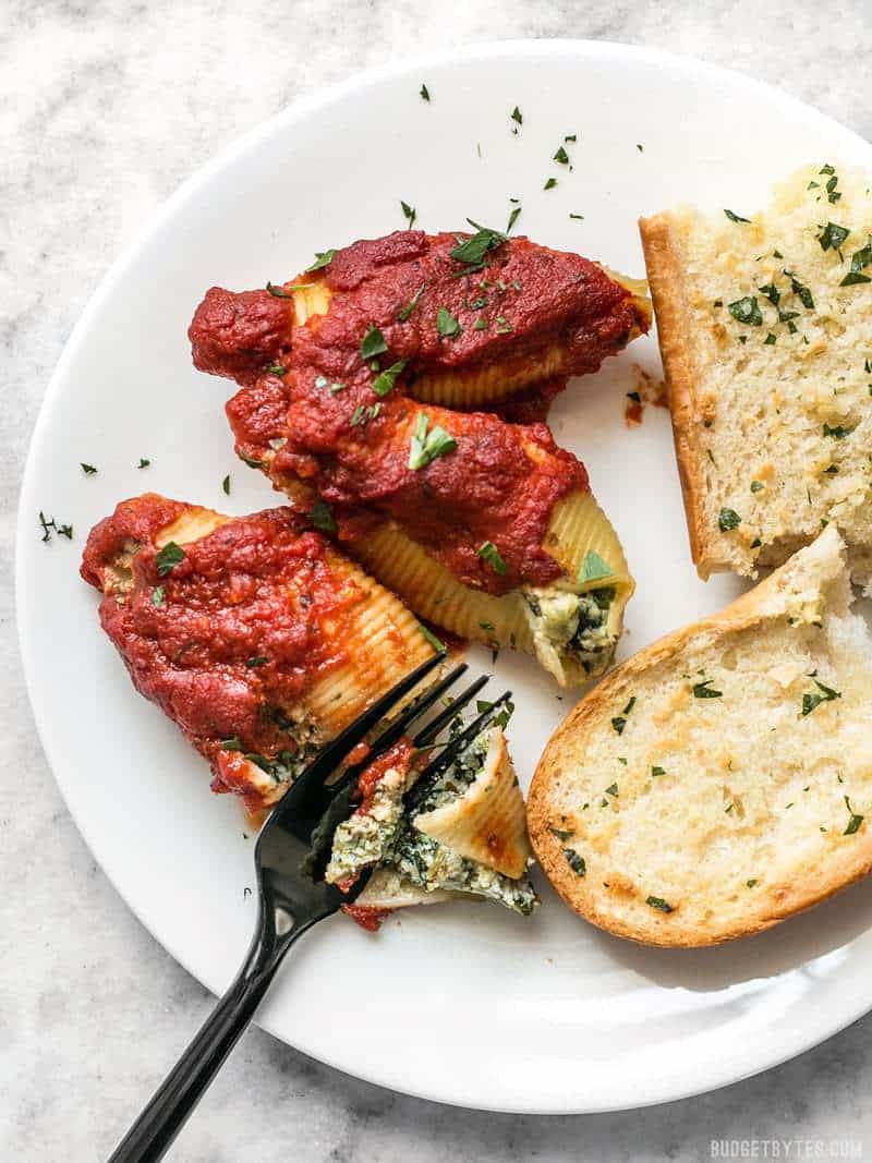 Pesto Stuffed Shells served on a plate with garlic bread.