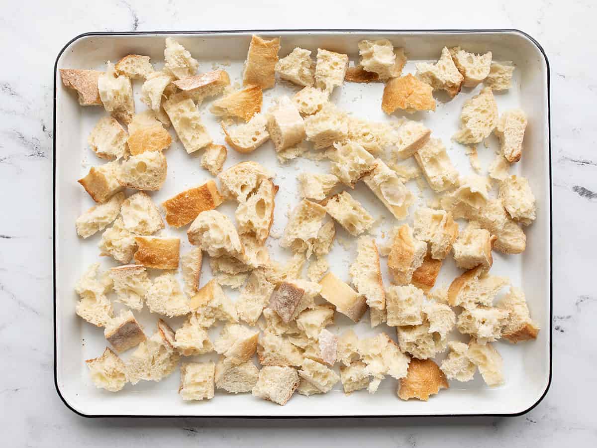 Torn bread pieces on a baking sheet