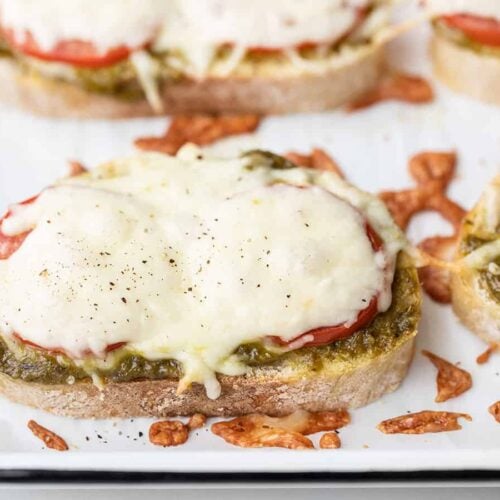 close up side view of pesto cheese toast on the baking sheet