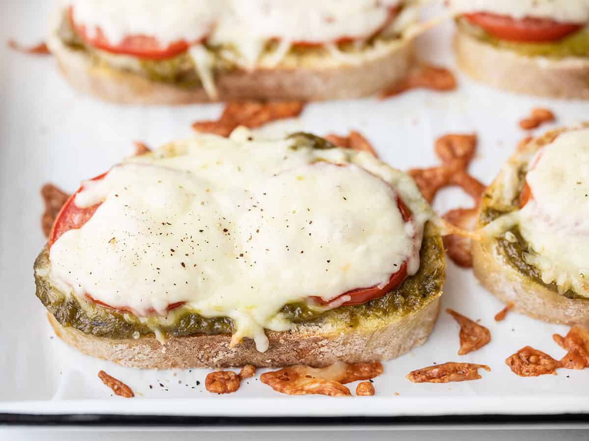 close up side view of pesto cheese toast on the baking sheet