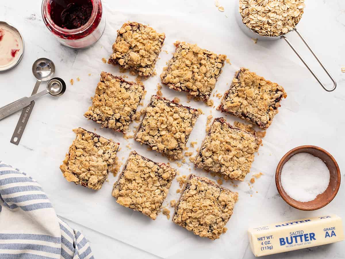 Overhead view of raspberry oatmeal bars cut into squares with ingredients on the sides