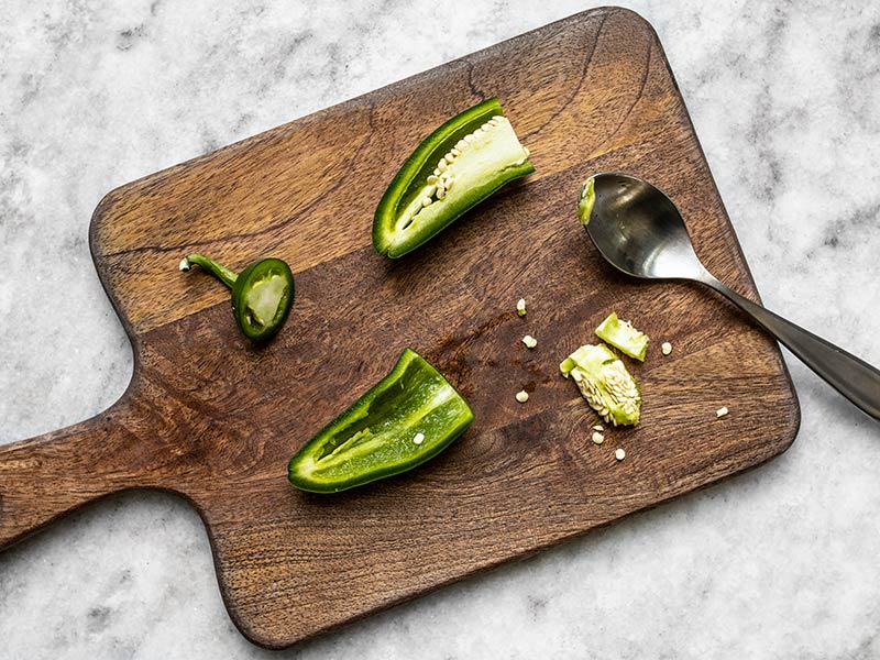 Jalapeño cut open on a wooden cutting board