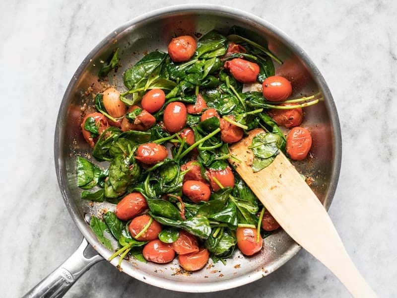 Wilted Spinach in the skillet with tomatoes and garlic