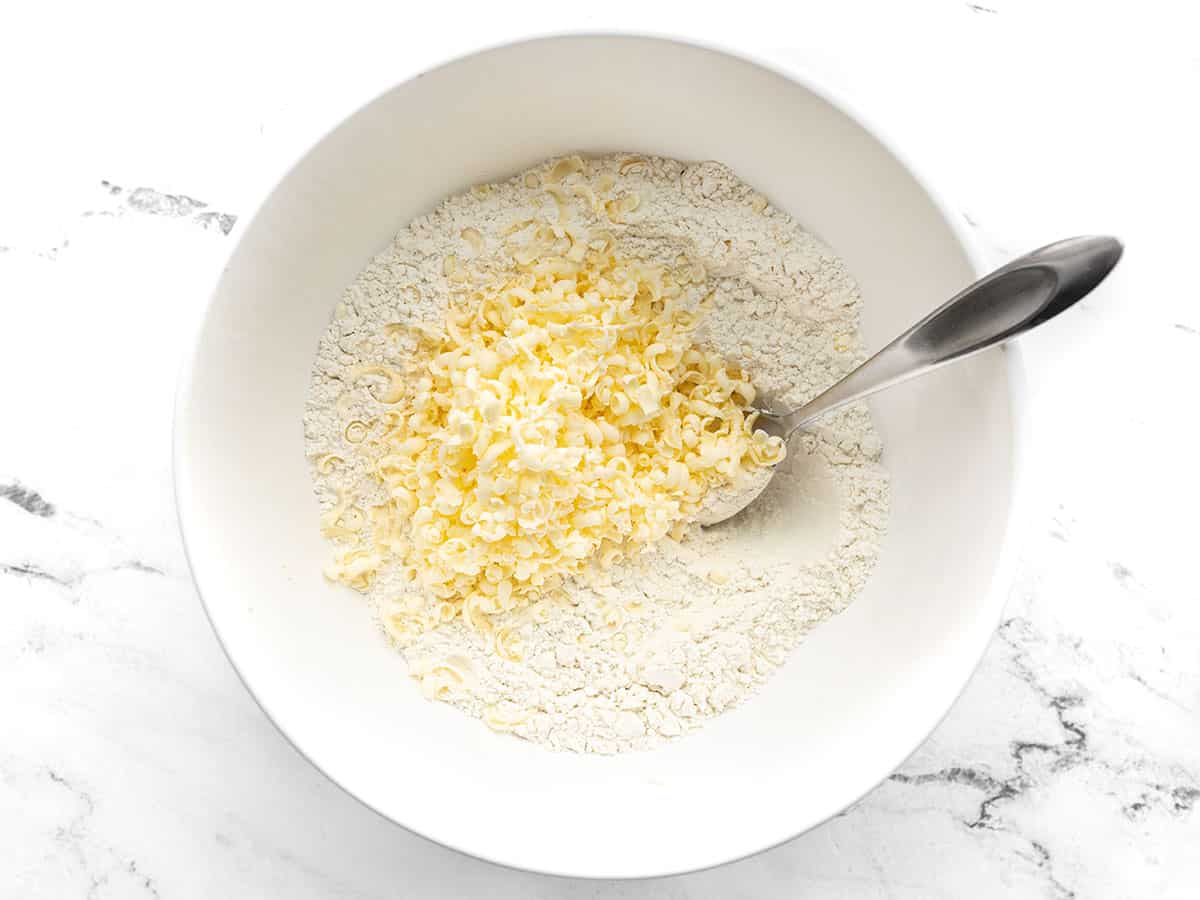 Grated butter added to the flour mixture in the bowl