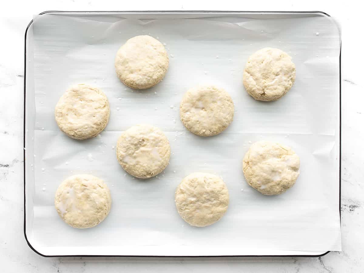 Unbaked biscuits on a lined baking sheet