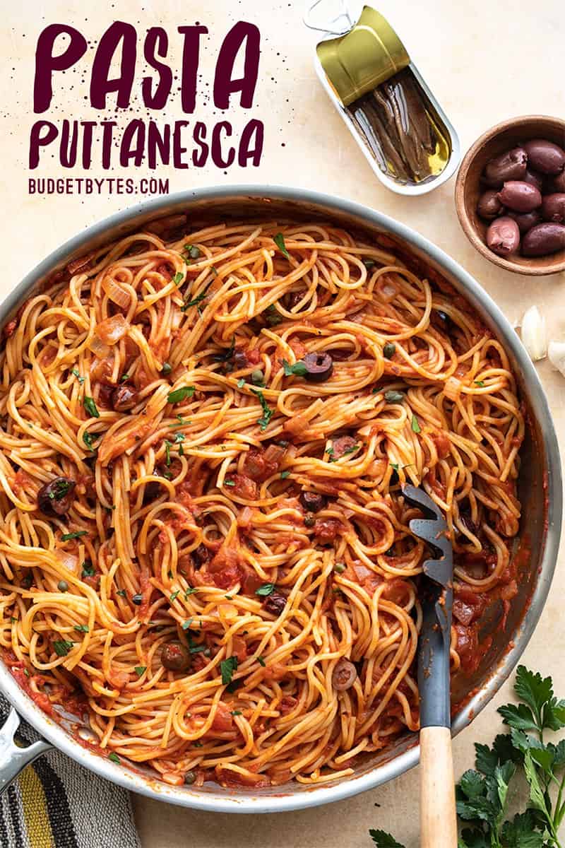 A full skillet of pasta puttanesca with title text at the top