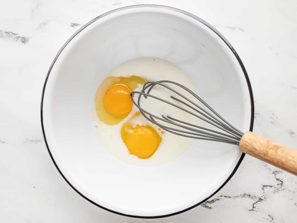 Milk and eggs in a bowl with a whisk