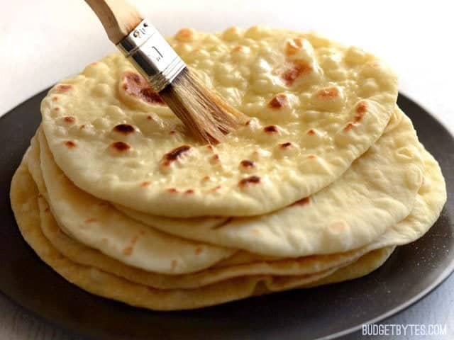 Brush Homemade Naan with Butter - BudgetBytes.com