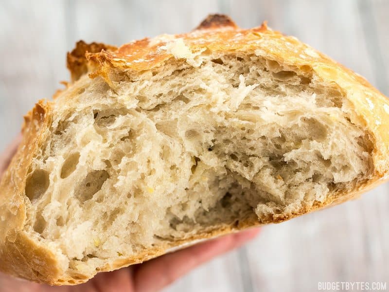 There is no kneading required to make these homemade focaccia rolls that have a crispy exterior and a soft, fluffy interior. Budgetbytes.com Close up of a no-knead bread loaf torn open