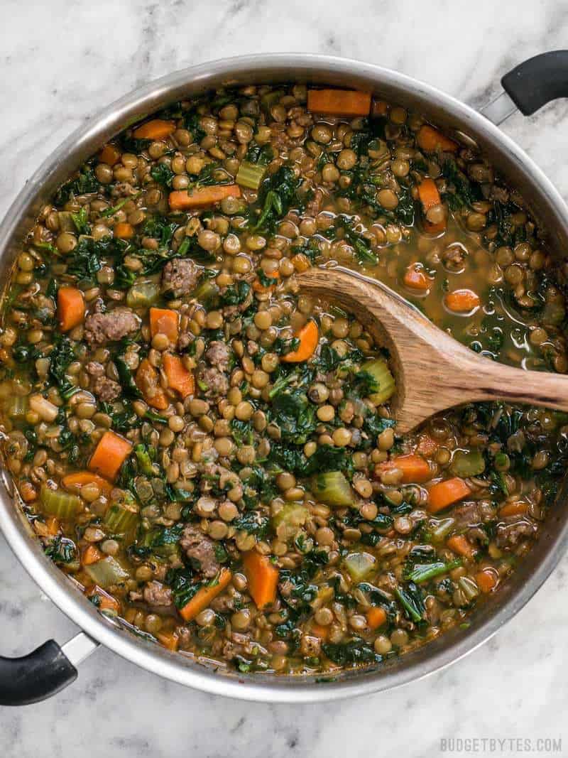 Lentil & Sausage Stew in pot with wooden spoon 
