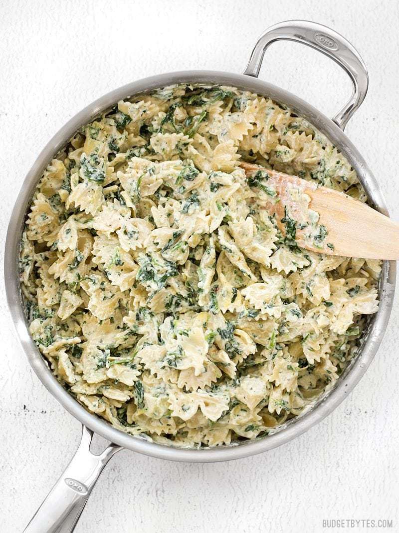 Spinach Artichoke Pasta in pan with wooden spoon