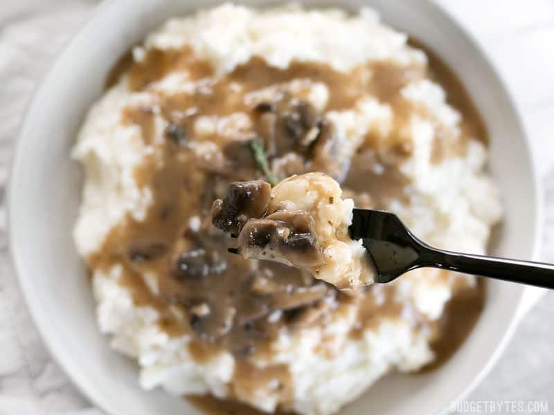 Close up of fork with mashed potatoes and gravy 