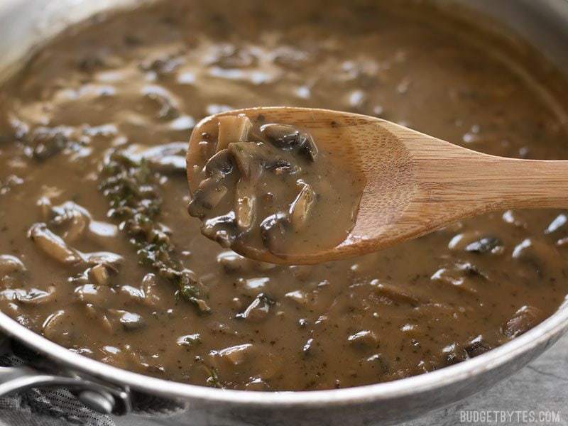 close up of gravy in pan with wooden spoon