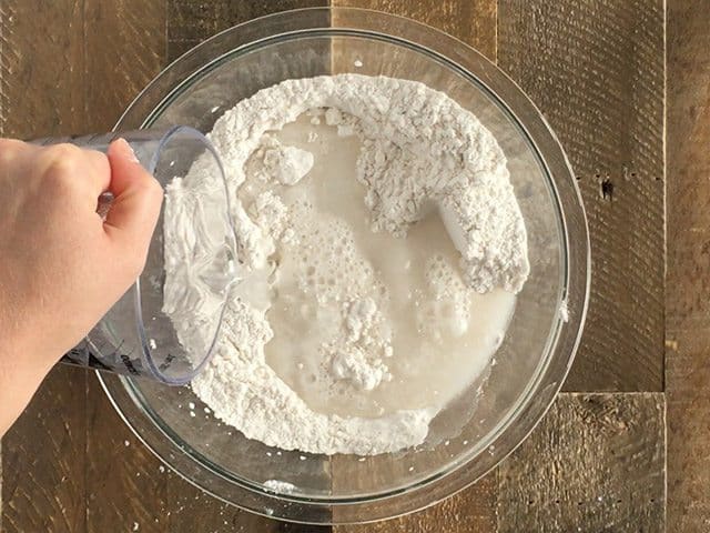 water being added to dry ingredients in mixing bowl 