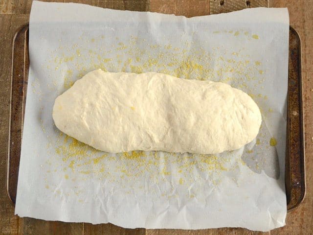 Risen Ciabatta Dough on baking sheet lined with parchment paper 