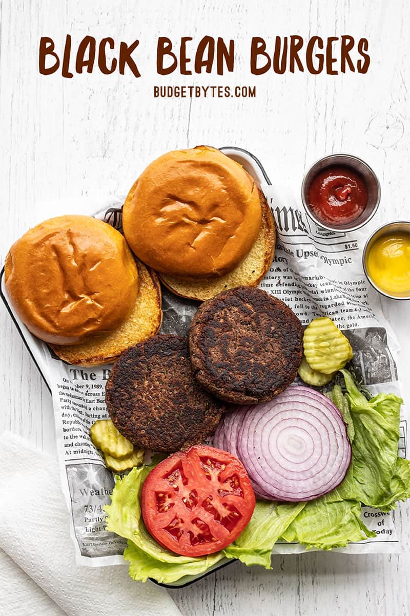 Two black bean burgers on a tray with buns and toppings. Title text at the top.