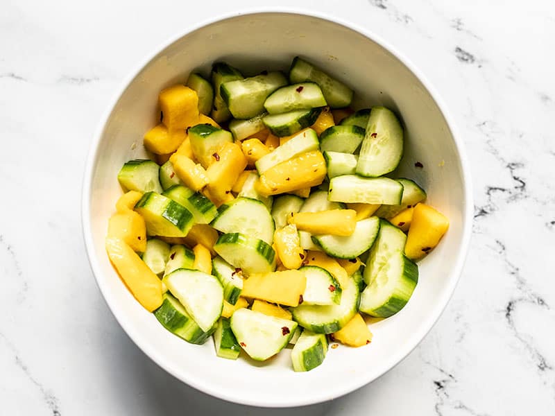 Finished cucumber mango salad in a white bowl