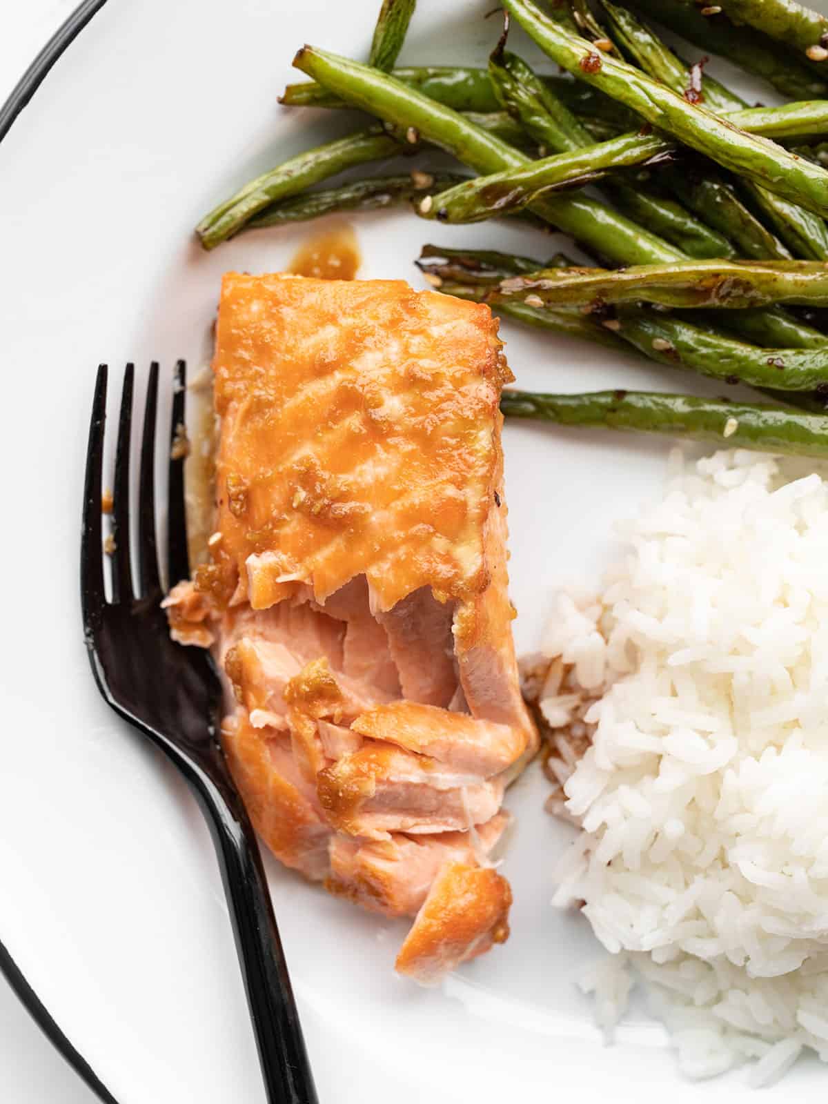 Baked ginger salmon on a plate with green beans and rice