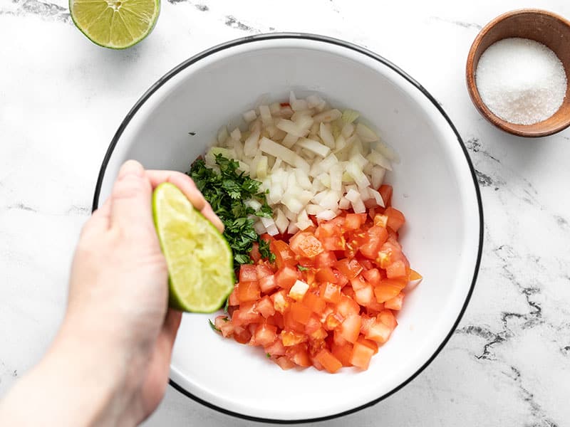 lime being squeezed over the bowl of vegetables