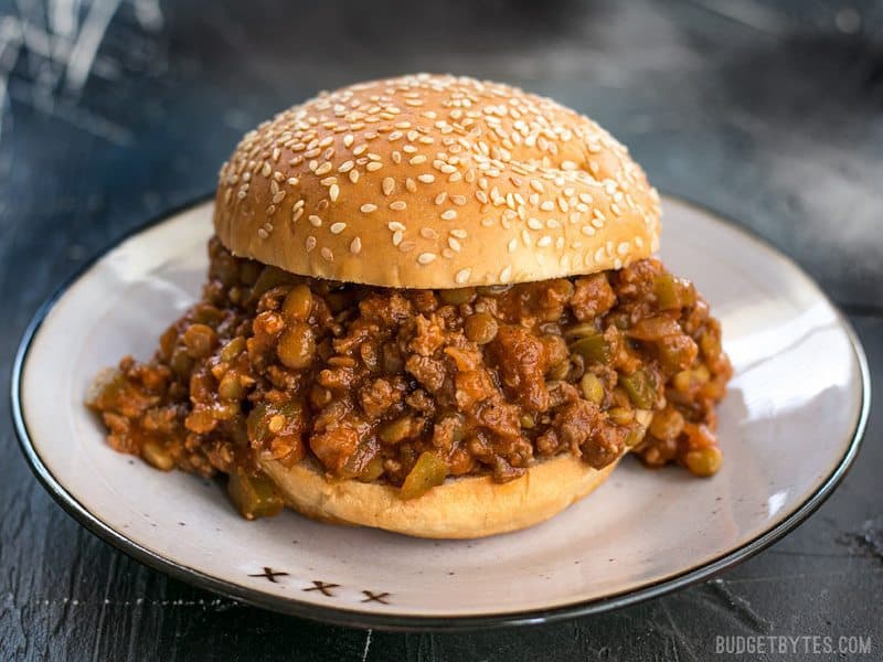 Soft Sesame Seed Bun Stuffed Full of Homemade Sloppy Joes Plus on Plate