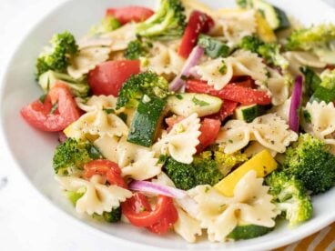 close up side view of a bowl of summer vegetable pasta salad