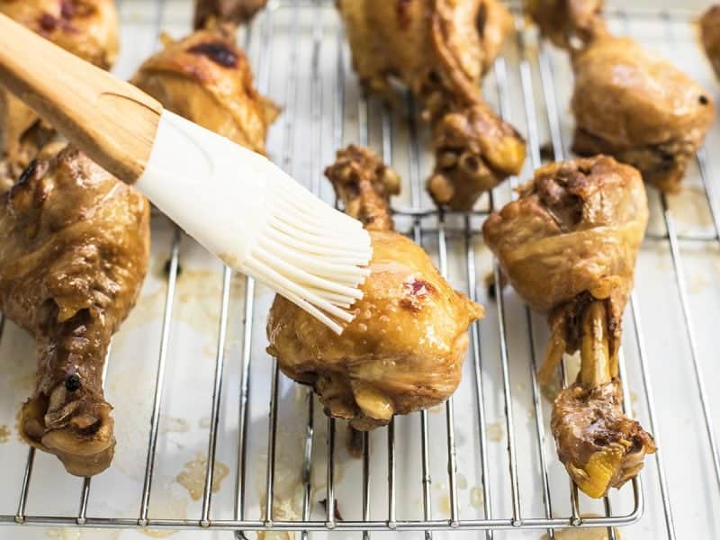 Chicken Adobo being basted with sauce 