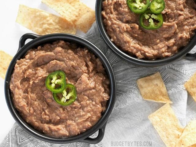 Two bowls of slow cooker (not) Refried Beans with jalapeño garnishes