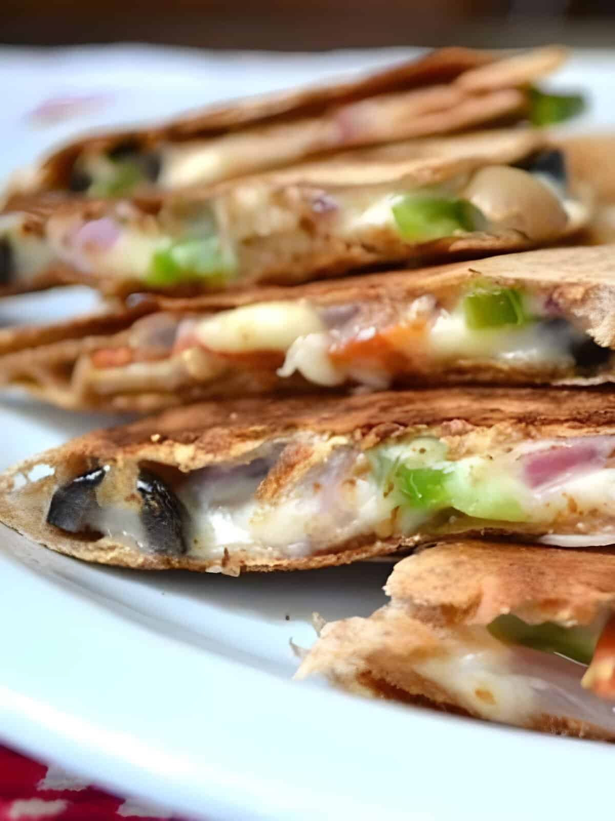Side view of a sliced pizzadilla on a plate.