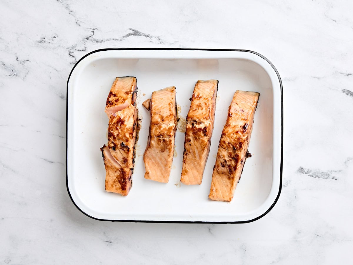 Pan fried teriyaki salmon in a baking dish.