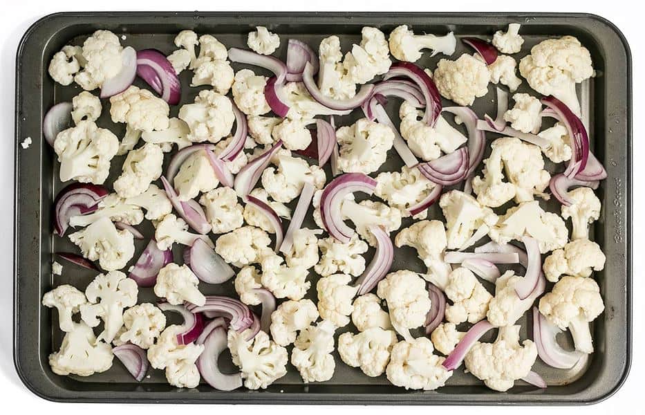 Cauliflower Florets and Sliced Red Onions on a sheet pan.