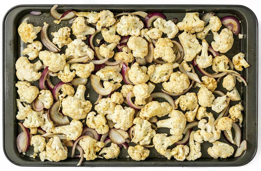 Seasoned Cauliflower and onions on a sheet pan