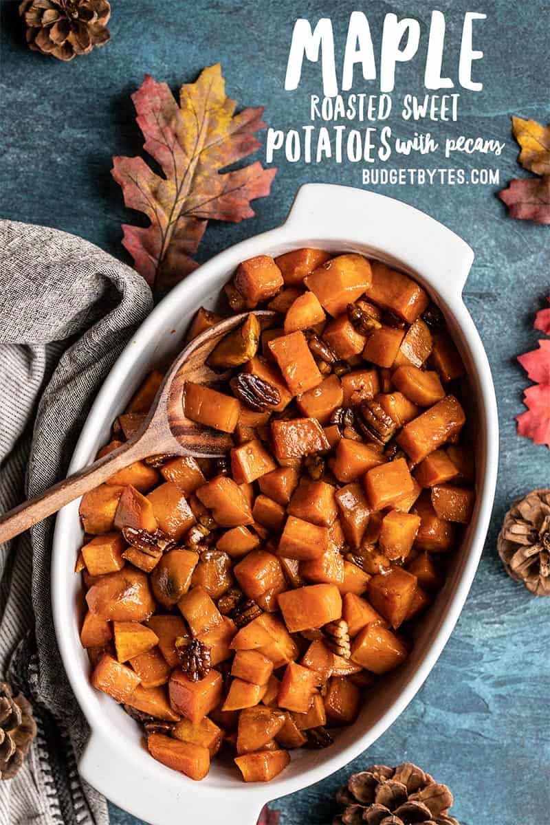 Maple roasted sweet potatoes in a white casserole dish with a wooden spoon, title text at the top.