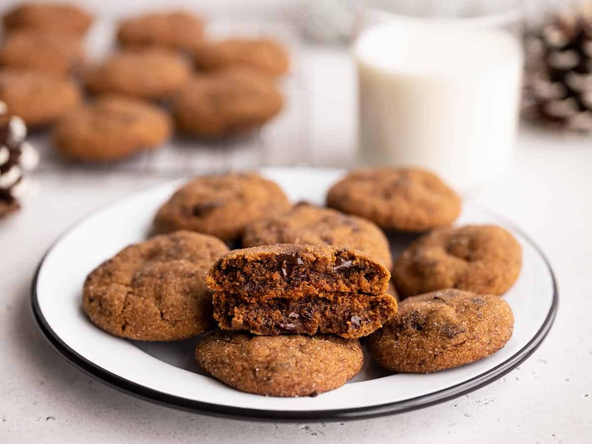 Chocolate molasses cookies on a plate with the cooling rack and glass of milk in the background