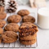 Chocolate molasses cookies stacked on a cooling rack