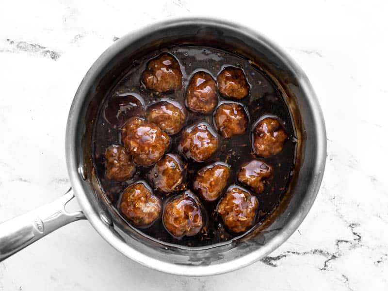 Meatballs coated in teriyaki sauce in the sauce pot