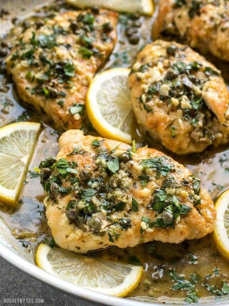 Close up of Chicken Piccata with lemon garlic sauce, capers, and parsley.