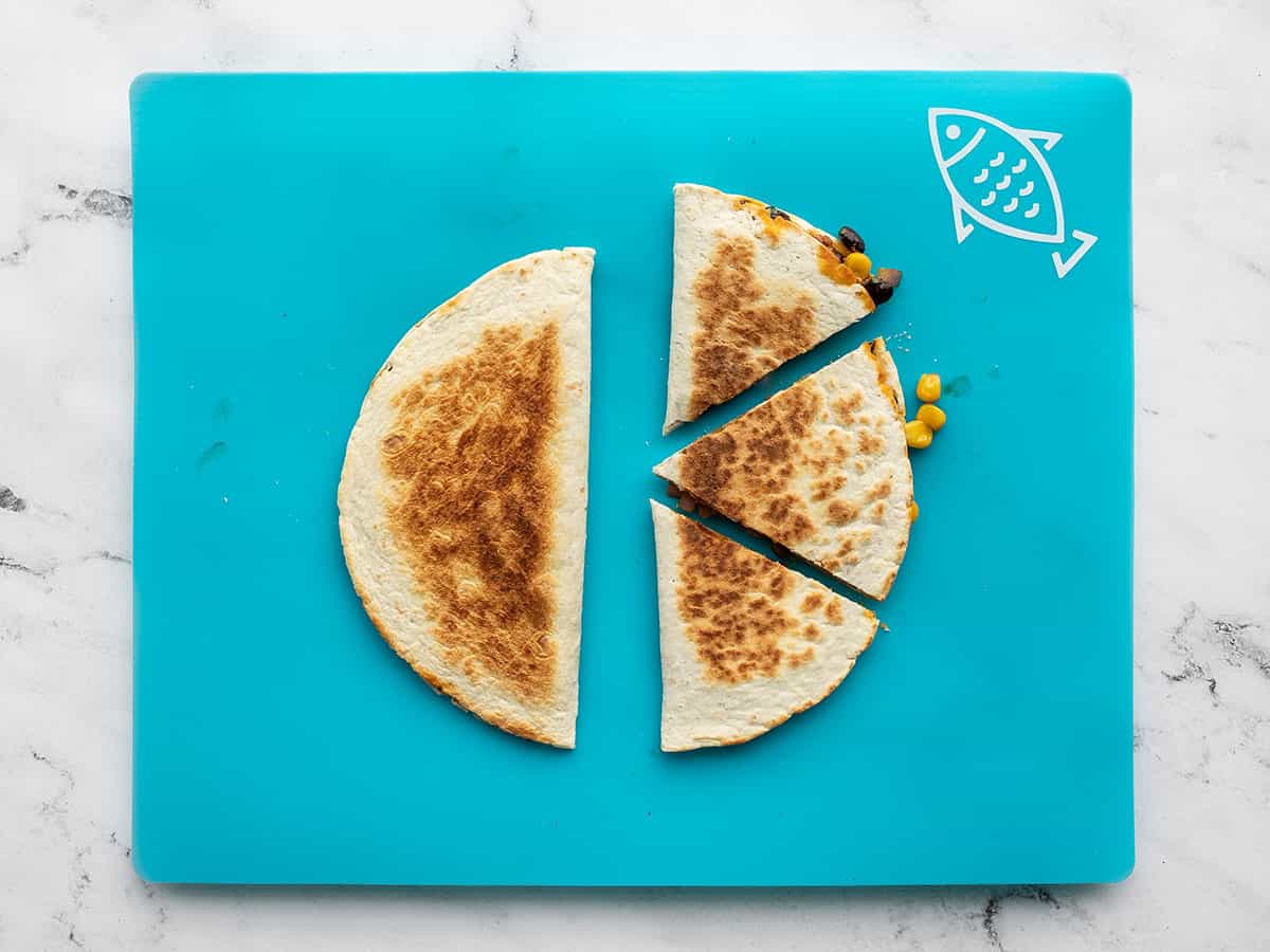 cut quesadillas on a cutting board