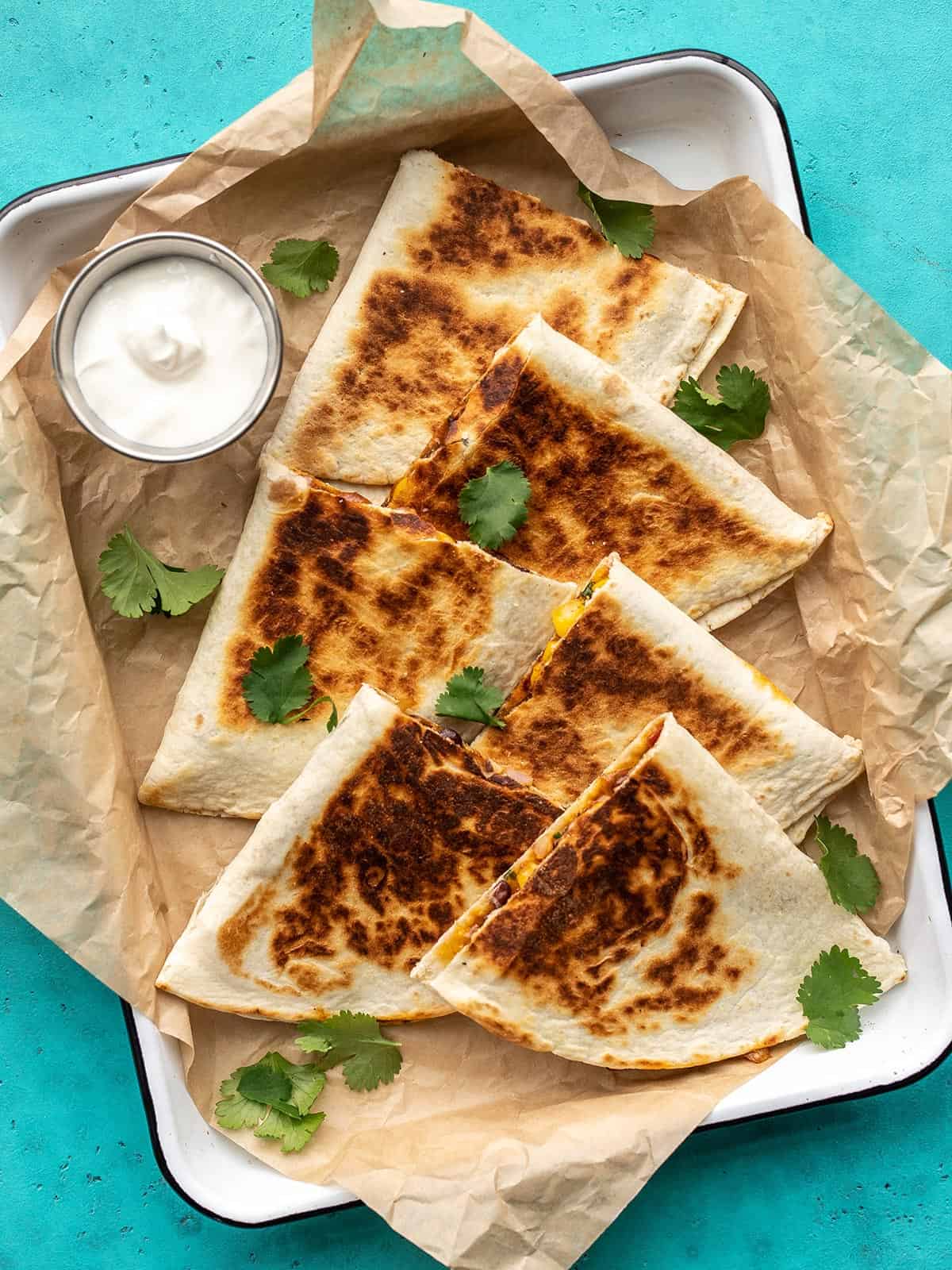 Overhead view of cut black bean quesadillas on a baking sheet