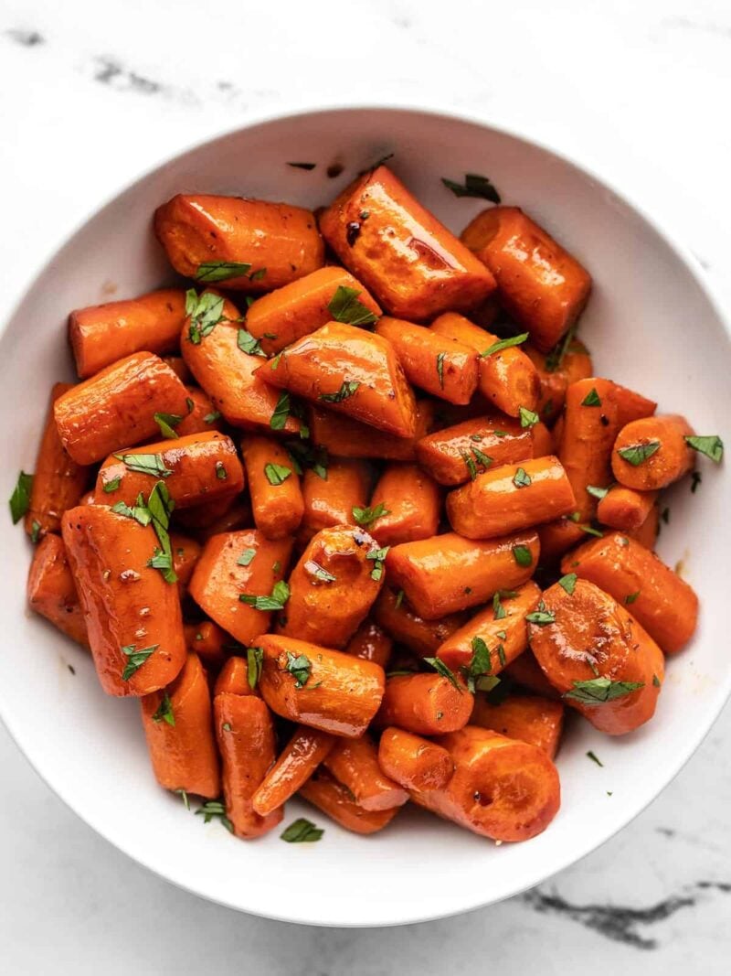 A bowl of honey balsamic glazed carrots garnished with parsley