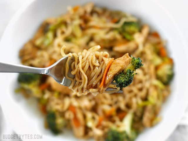A forkful of Chicken Yakisoba noodles twirled around the fork with Vegetables