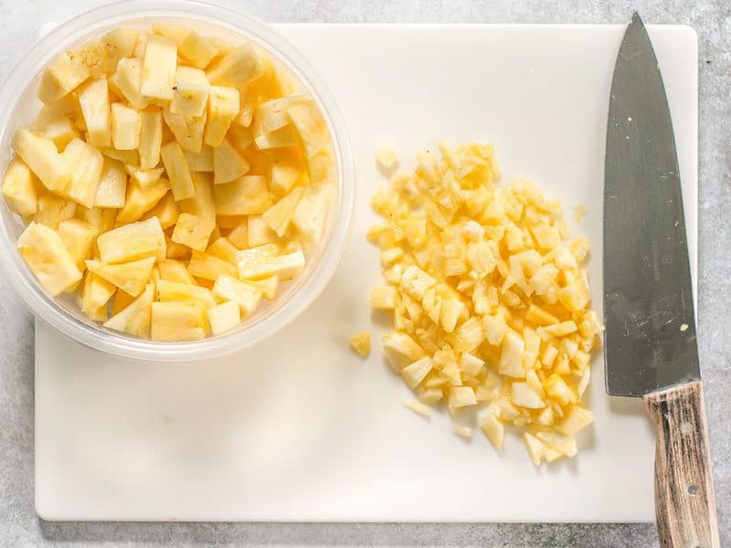Pineapple being chopped into smaller pieces