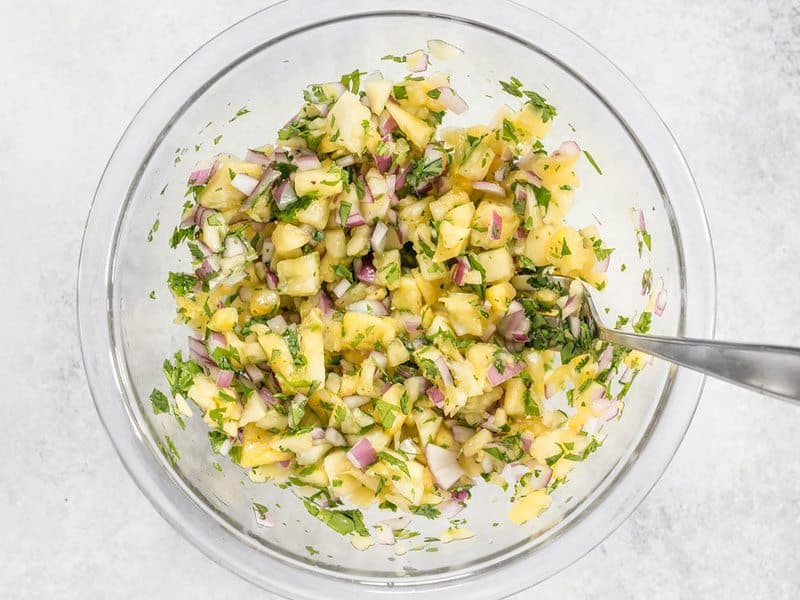 Finished Pineapple Salsa in the mixing bowl with a spoon