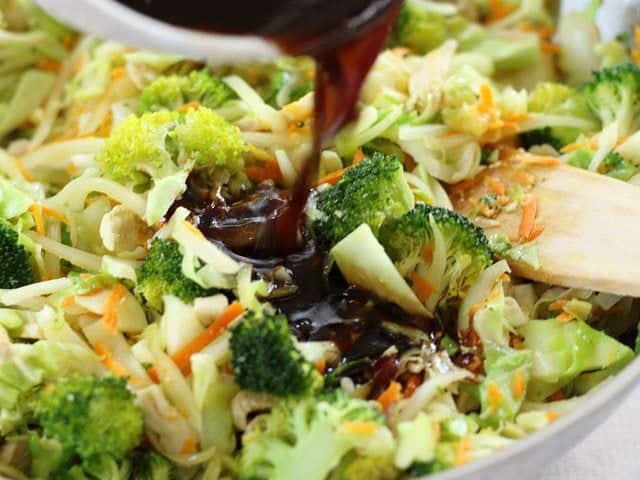 Yakisoba Sauce being poured over vegetables in the skillet